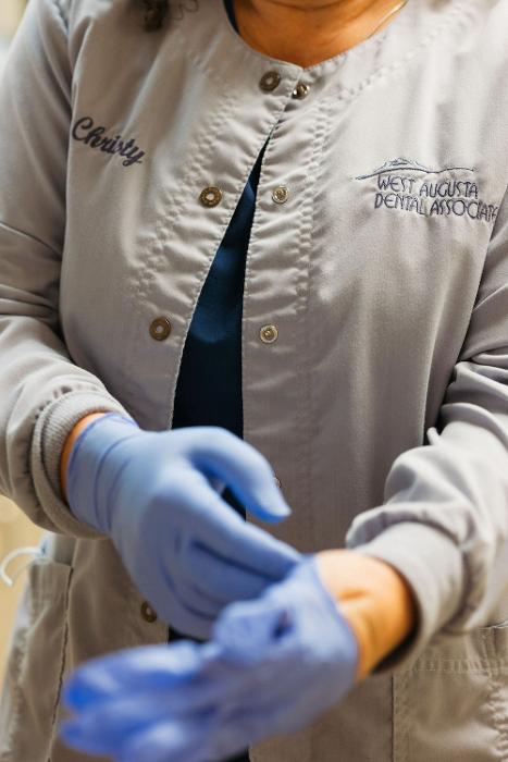 One of our general dentists in Augusta putting on gloves