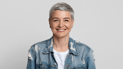 Older woman with short gray hair smiling confidently, showing healthy white teeth